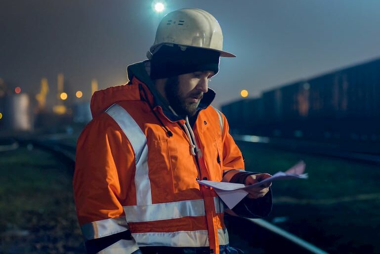 Nachtarbeiter geht seine Unterlagen auf der Baustelle durch